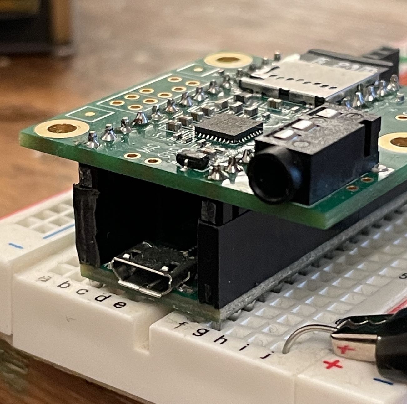 A closeup image of the teensy 4.x audio shield stacked on top of a Teensy 4.1, which is then inserted into a breadboard